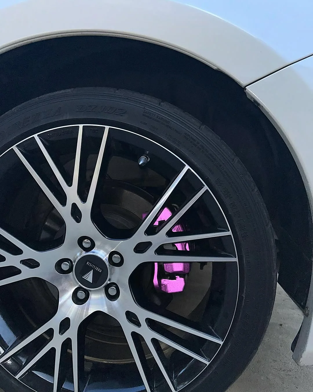 Pink wrapped brake caliper seen through the spokes of a Toyota GT86 wheel