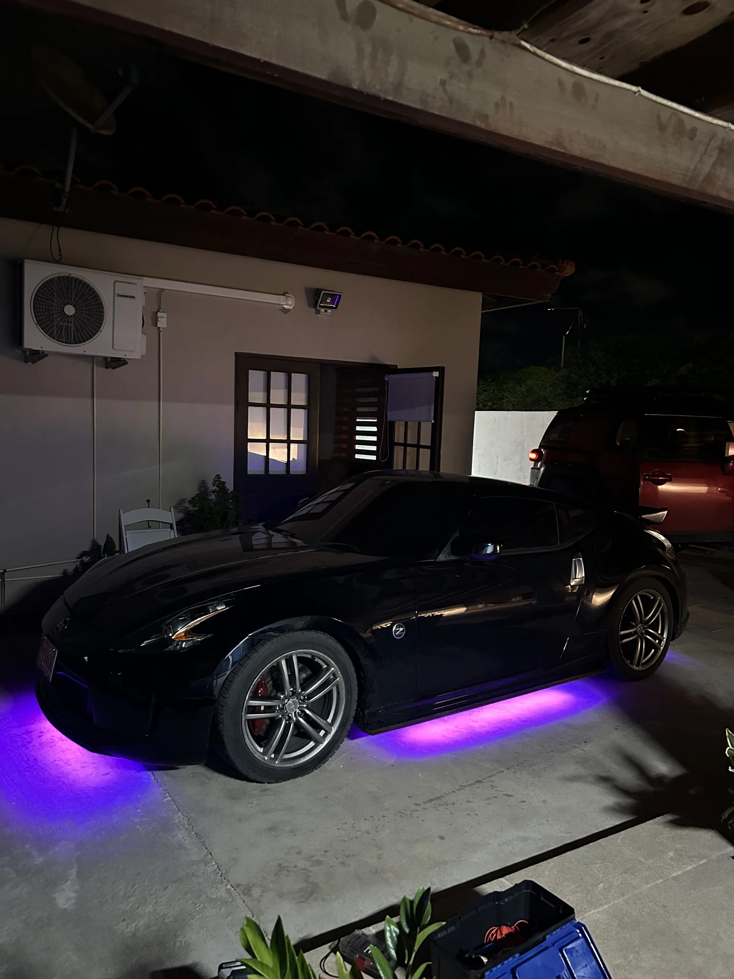 Purple underglow lighting the road under a car at night